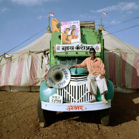 Jonathan Torgovnik.
Amar Touring Cinema camped in the village of Palli, with Kisan the projector operator sitting on the truck. 
2002. 
Presented by Admira, Milan