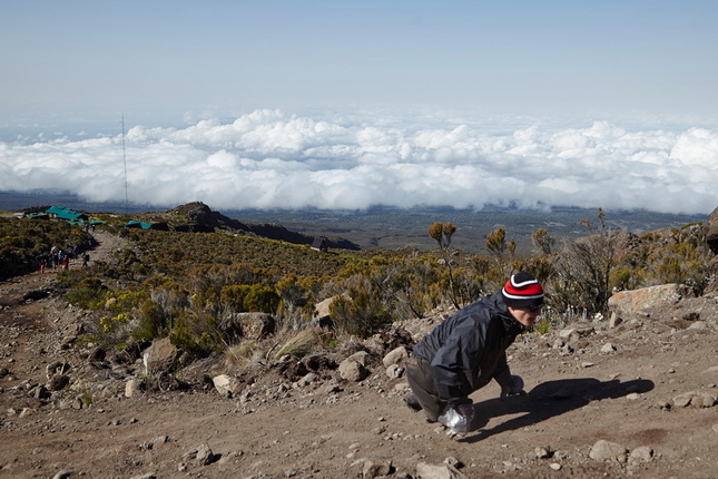 Стив Ремих.
Саша Шульчев начинает свой день над облаками, уходя из лагеря в Хоромбо, четвертый день подъема, Килиманджаро, Танзания.
Июнь, 2014