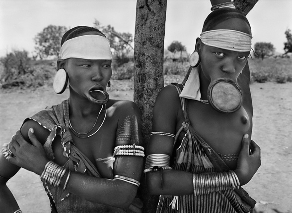 The Mursi and the Surma women are the last women in the world to wear lip plates. 
Mursi village of Dargui in Mago National Park, in the Jinka Region.
Ethiopia. 2007.
Photograph by Sebastião SALGADO / Amazonas images